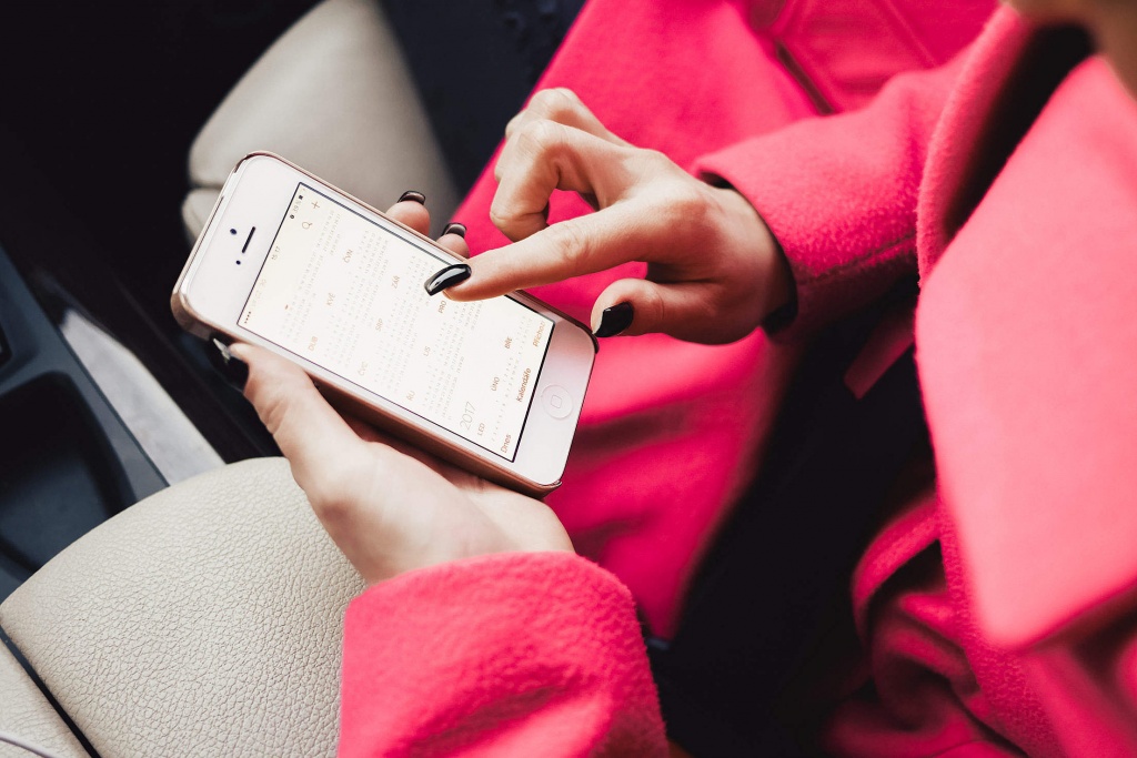 young-woman-planning-in-calendar-app-on-white-iphone-2210x1475.jpg